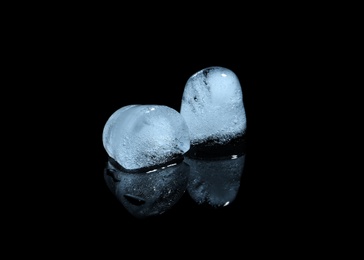 Photo of Melting ice cubes on black background. Frozen liquid