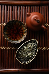 Photo of Aromatic Baihao Yinzhen tea and teapot on wooden tray, flat lay. Traditional ceremony