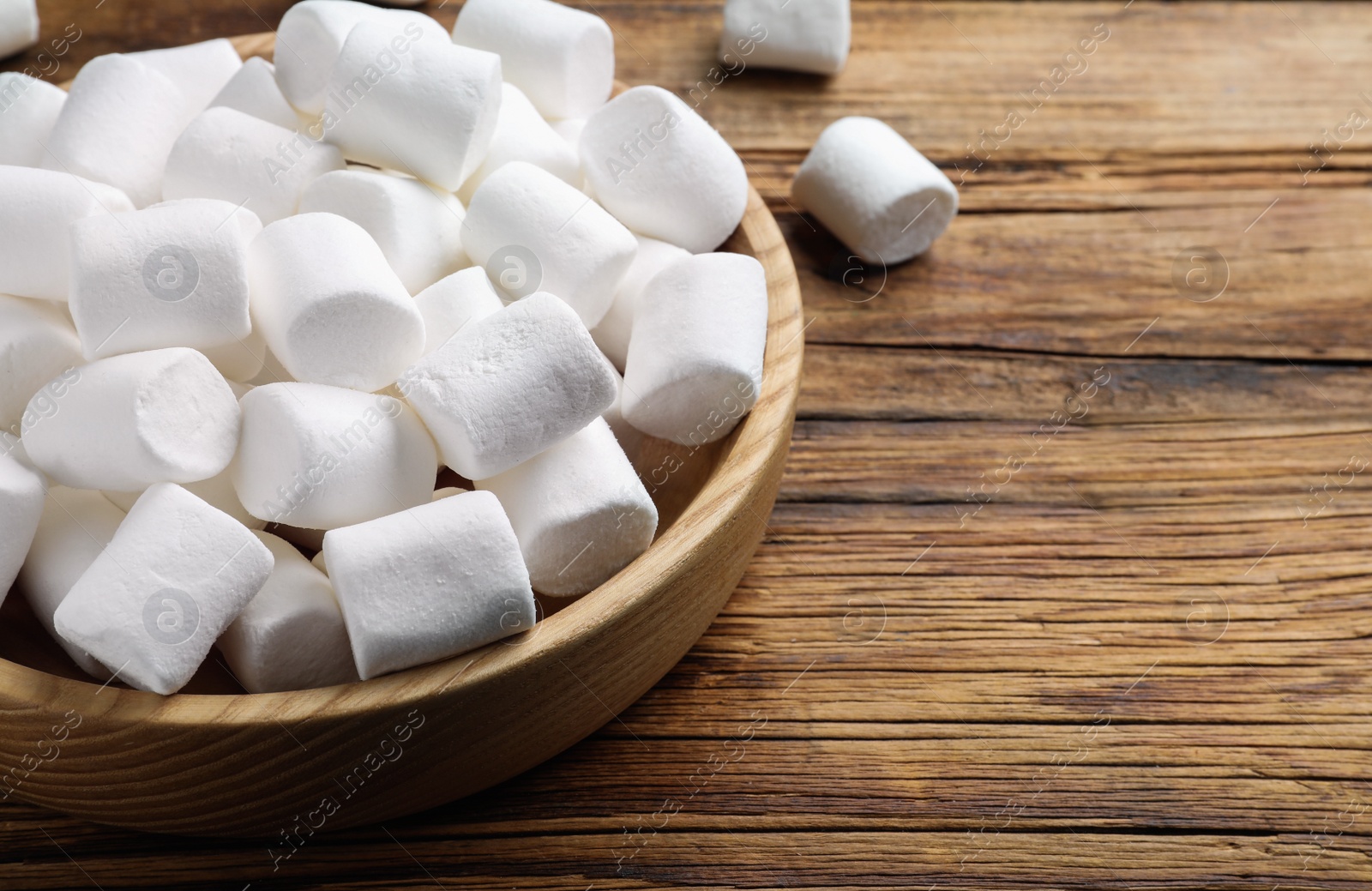 Photo of Delicious puffy marshmallows on wooden table, closeup