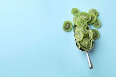 Photo of Scoop of dried kiwi on color background, top view with space for text. Tasty and healthy fruit