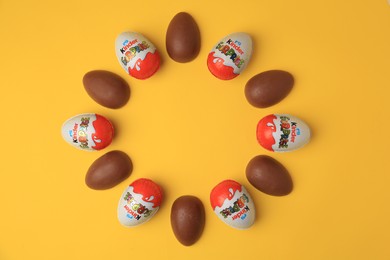 Photo of Sveti Vlas, Bulgaria - June 29, 2023: Frame of Kinder Surprise Eggs on orange background, flat lay. Space for text