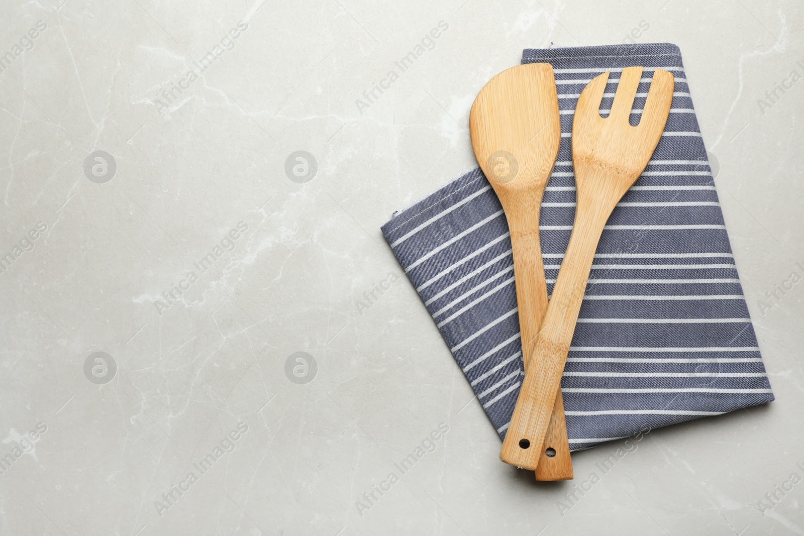 Photo of Different kitchen utensils and napkin on grey background, top view with space for text
