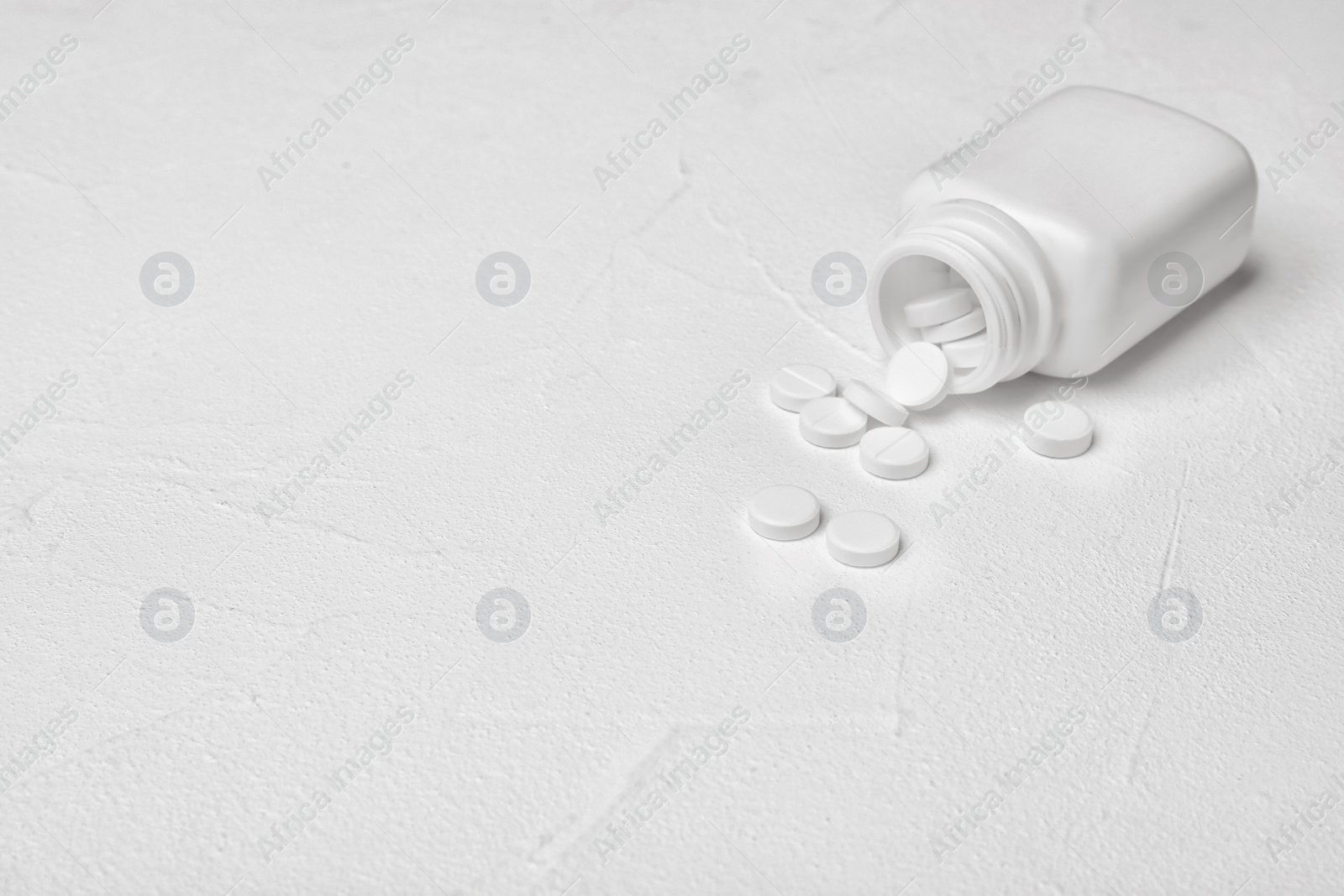 Photo of Container with pills on white background