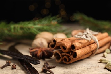 Cinnamon sticks and other spices on wooden table, closeup