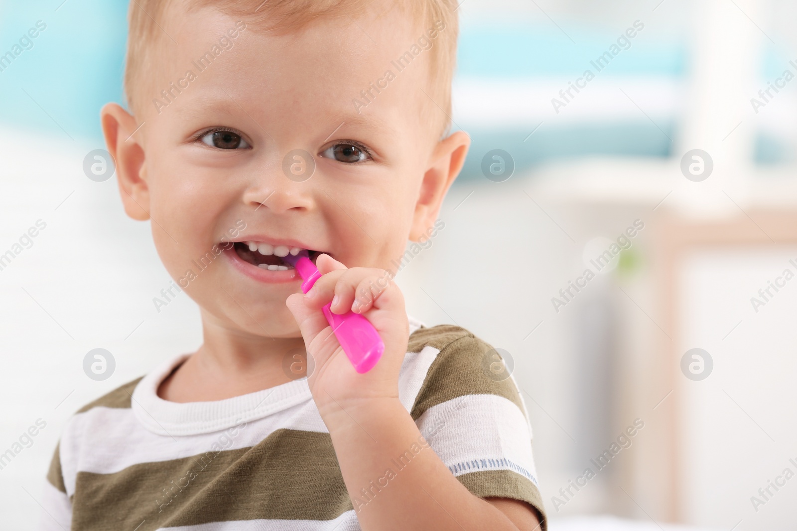 Photo of Cute little boy with toothbrush on blurred background