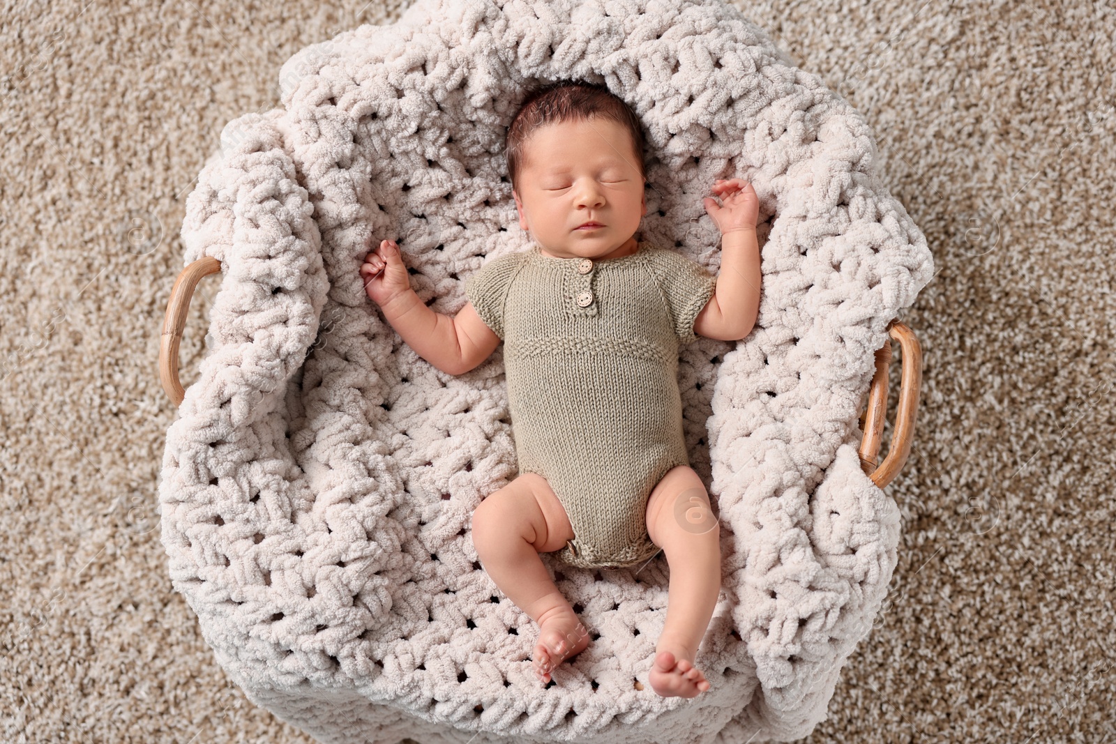 Photo of Cute newborn baby sleeping in basket, top view