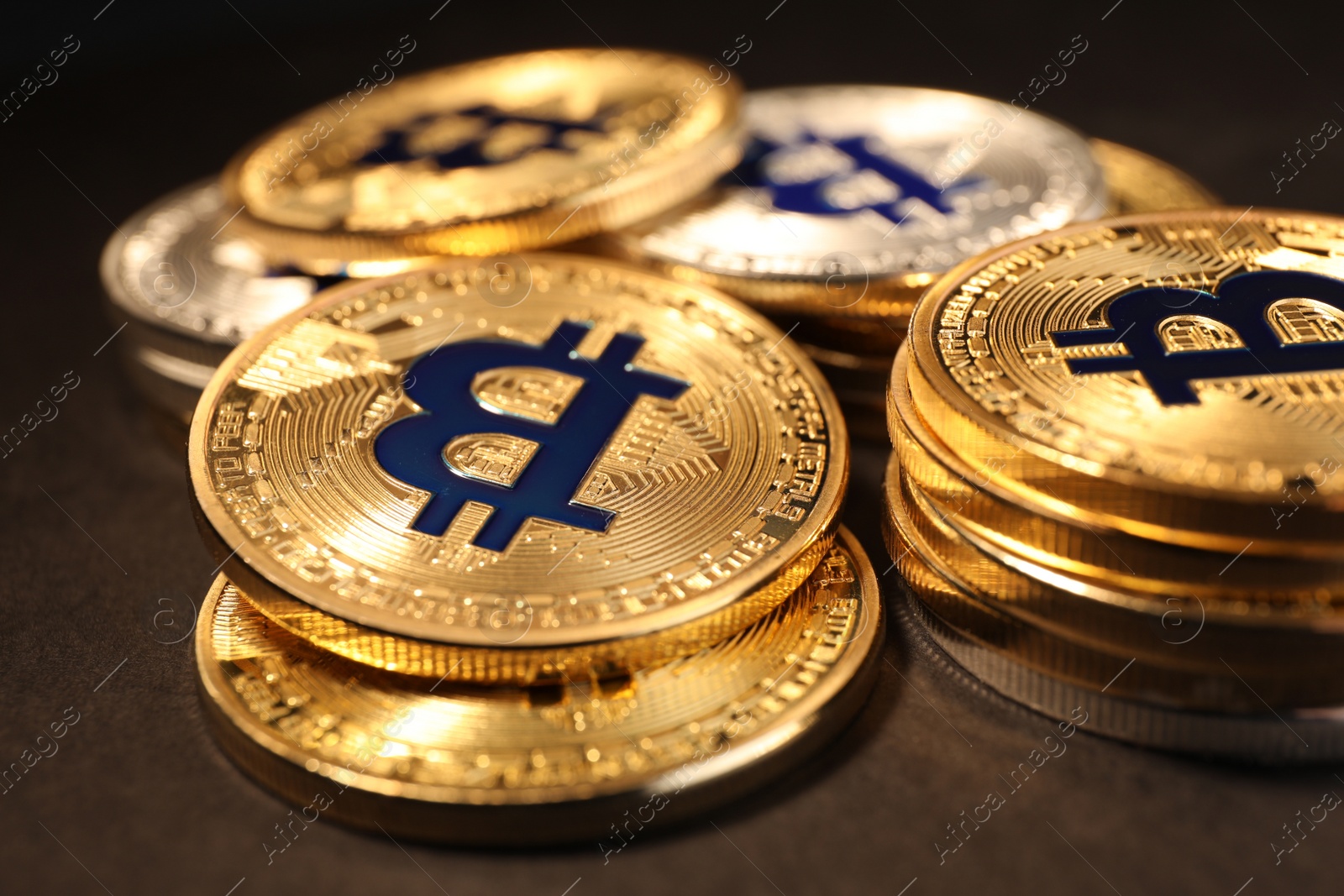 Photo of Shiny gold bitcoins on dark background, closeup view. Digital currency