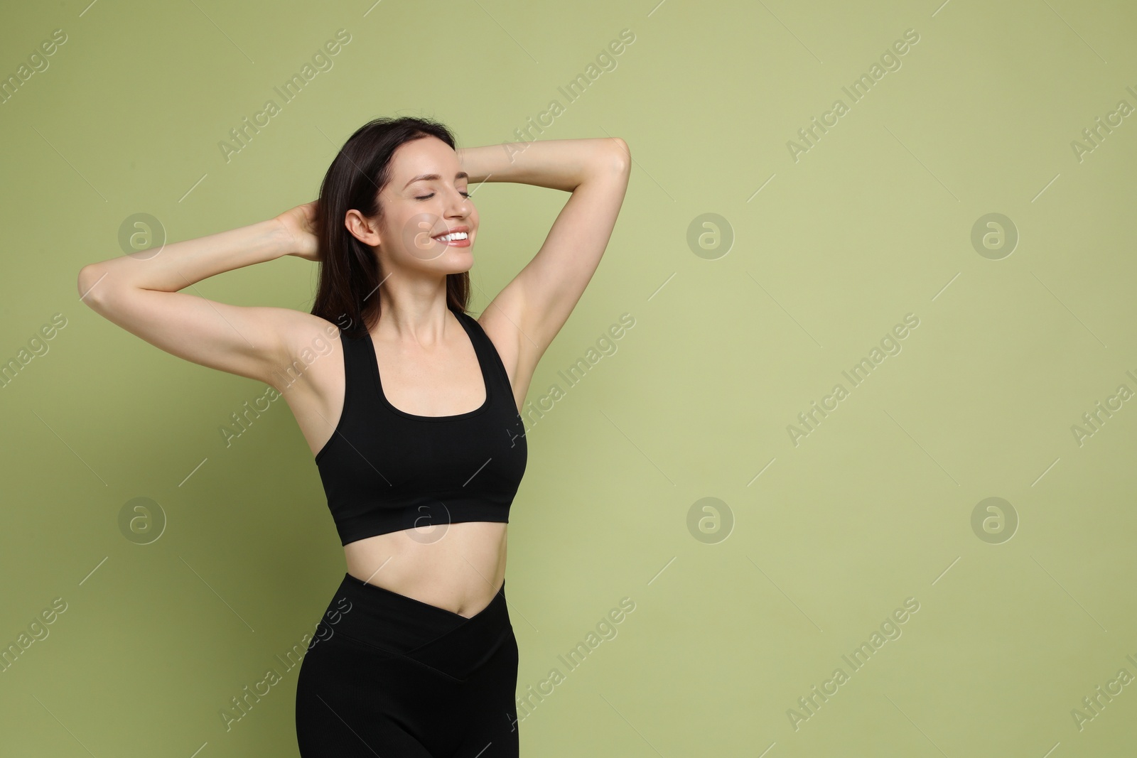 Photo of Happy young woman with slim body posing on green background, space for text