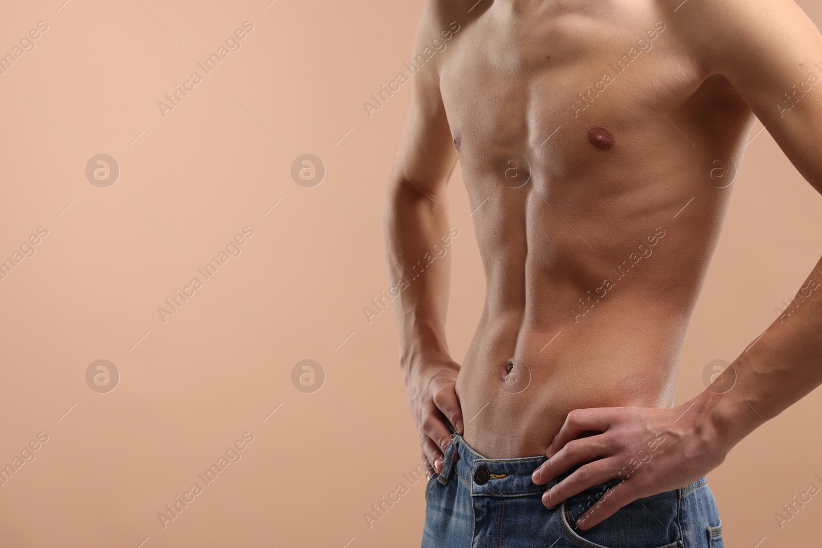 Photo of Shirtless man with slim body on beige background, closeup. Space for text