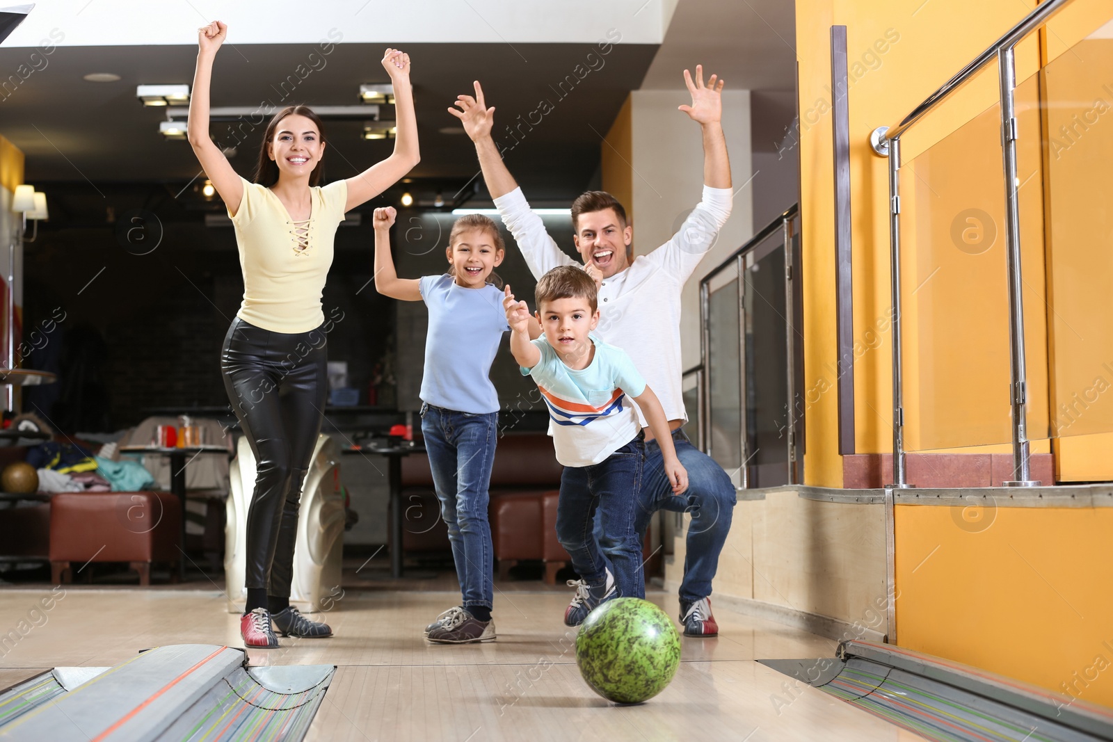 Photo of Happy family spending time together in bowling club