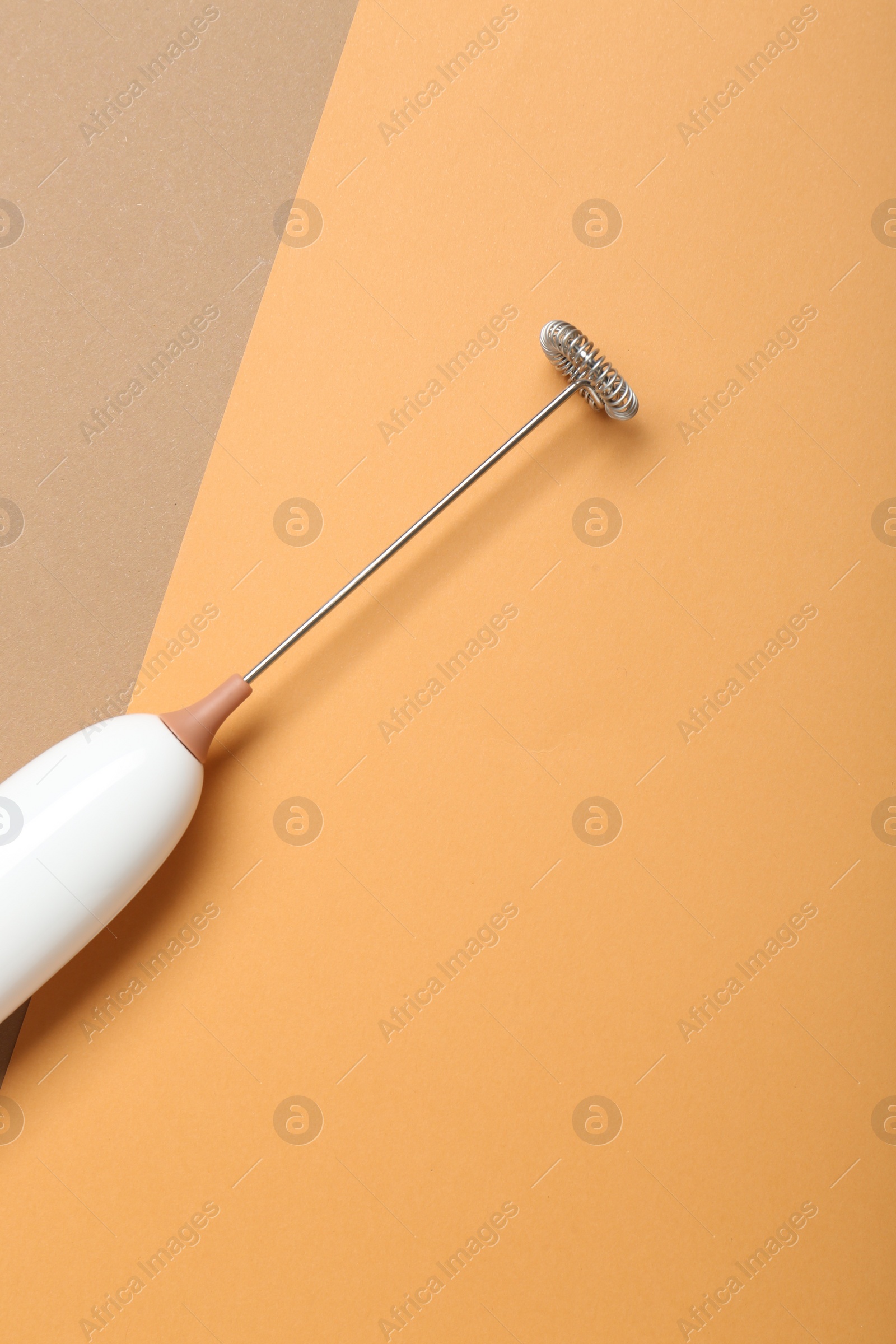 Photo of White milk frother wand on color background, top view