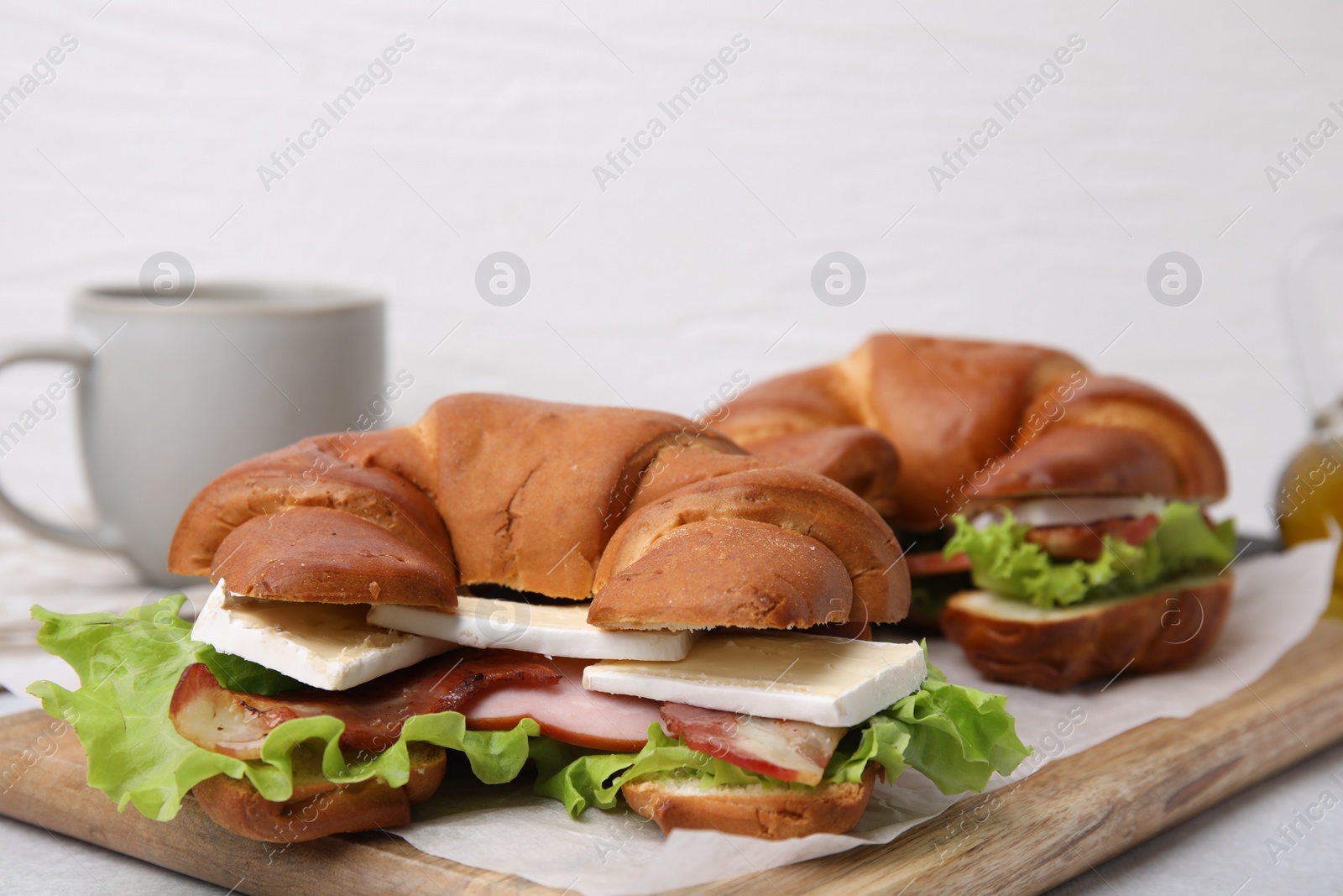 Photo of Tasty crescent rolls with brie cheese, ham and bacon on table, closeup