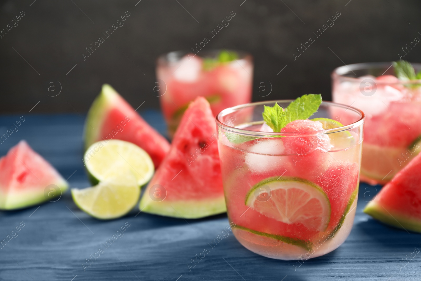 Photo of Delicious refreshing watermelon drink on blue wooden table