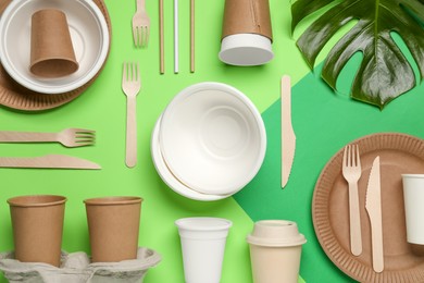 Photo of Flat lay composition with disposable tableware on green background