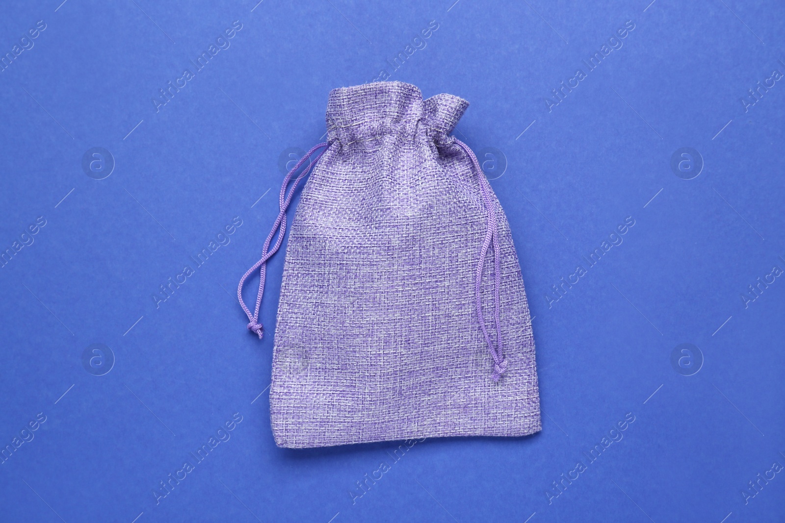 Photo of Violet burlap bag on blue background, top view