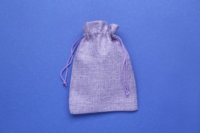 Photo of Violet burlap bag on blue background, top view