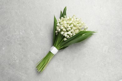 Beautiful lily of the valley bouquet on grey table, top view