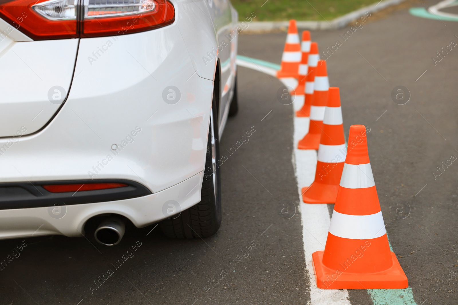 Photo of Modern car on test track with traffic cones, closeup. Driving school