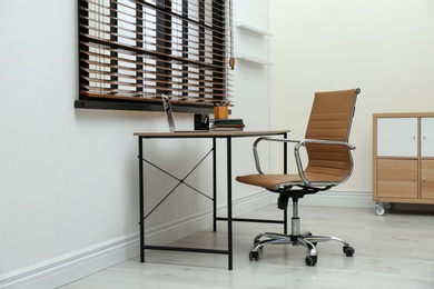 Photo of Stylish workplace interior with modern office chair