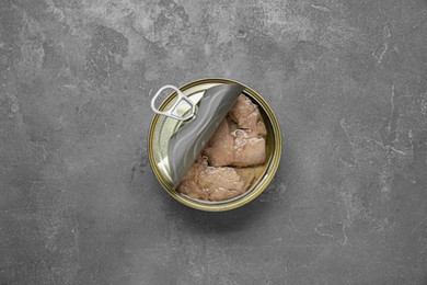 Open tin can of tasty cod liver on grey table, top view
