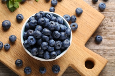 Photo of Tasty fresh blueberries on wooden table, flat lay