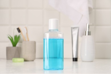 Photo of Bottle of mouthwash on white table in bathroom