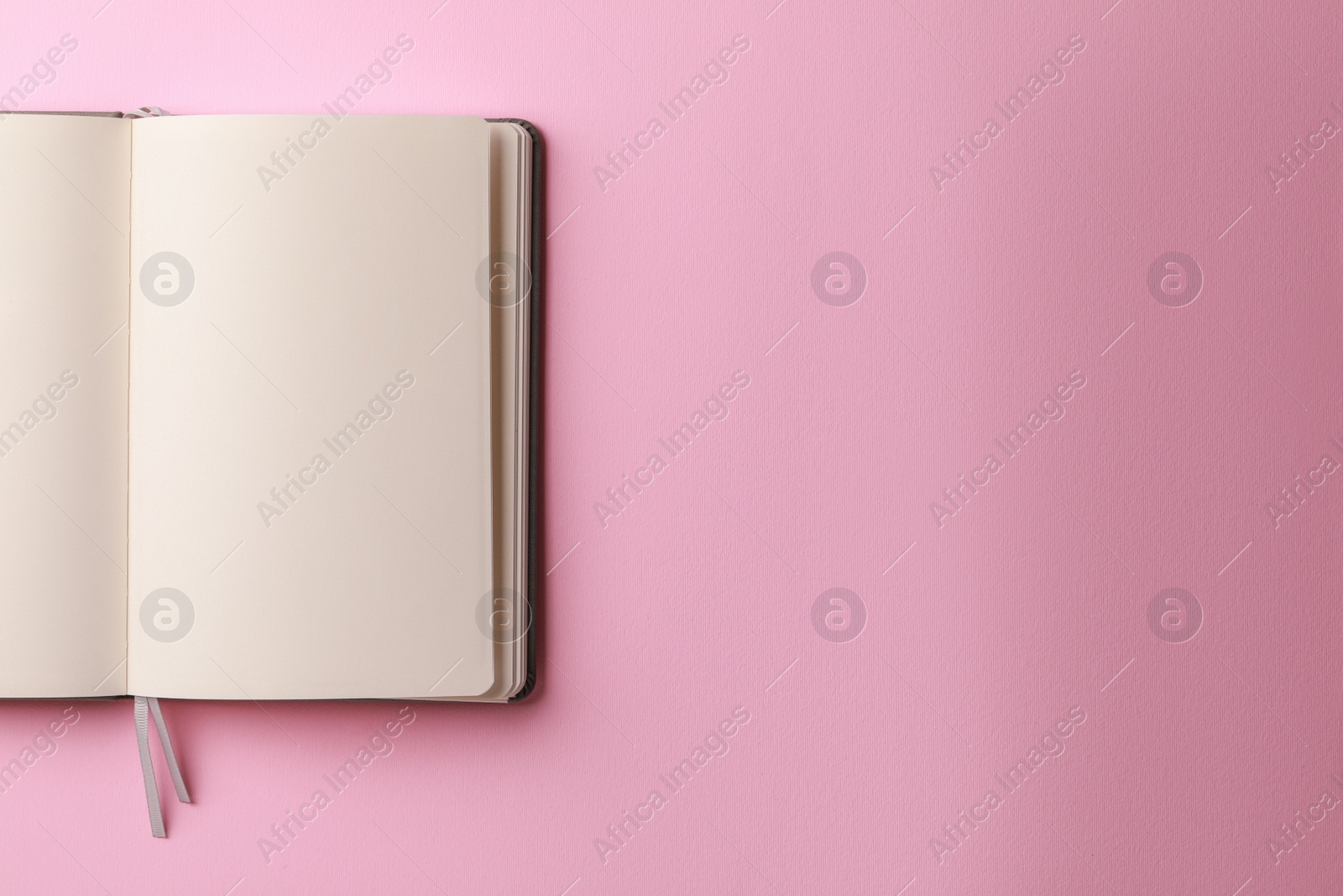 Photo of Blank notebook on pale pink background, top view. Space for text