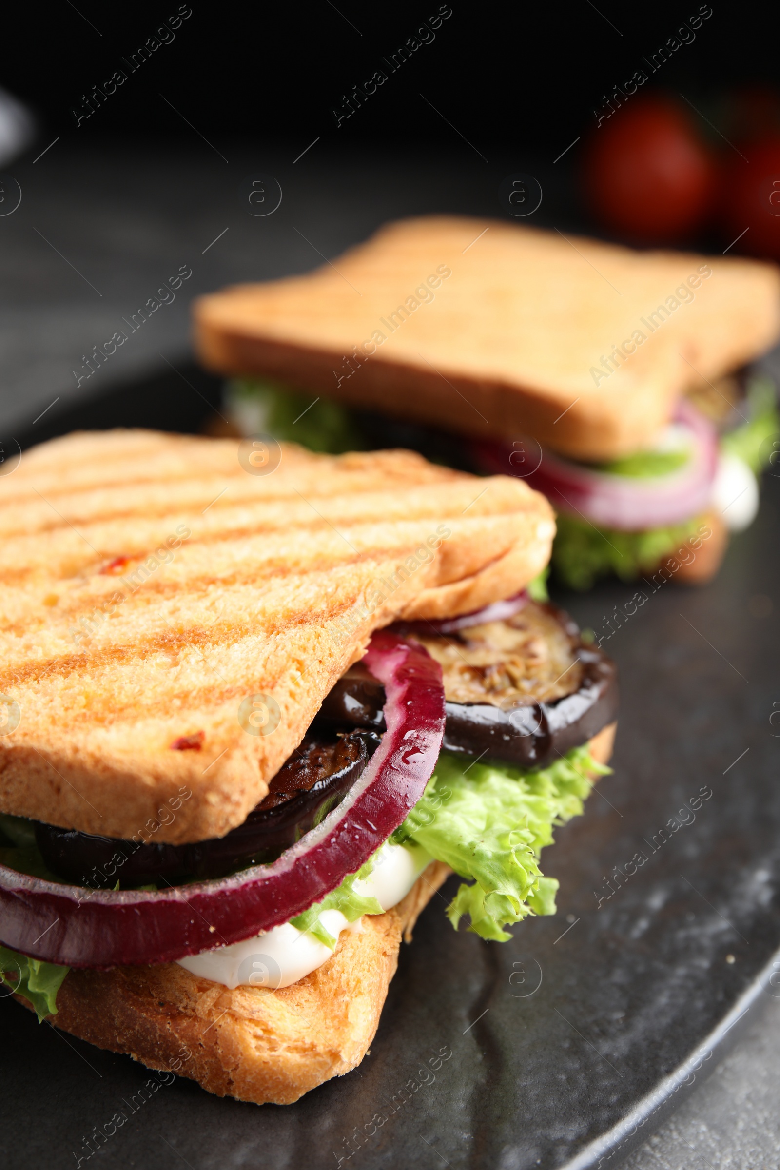 Photo of Delicious eggplant sandwiches on slate board, closeup