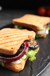 Photo of Delicious eggplant sandwiches on slate board, closeup
