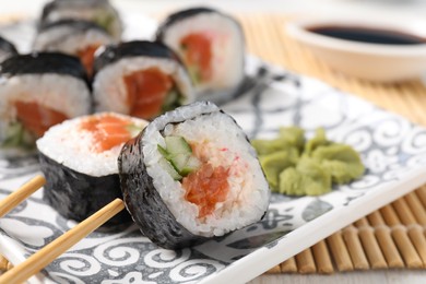 Photo of Tasty sushi rolls with wasabi served on table, closeup