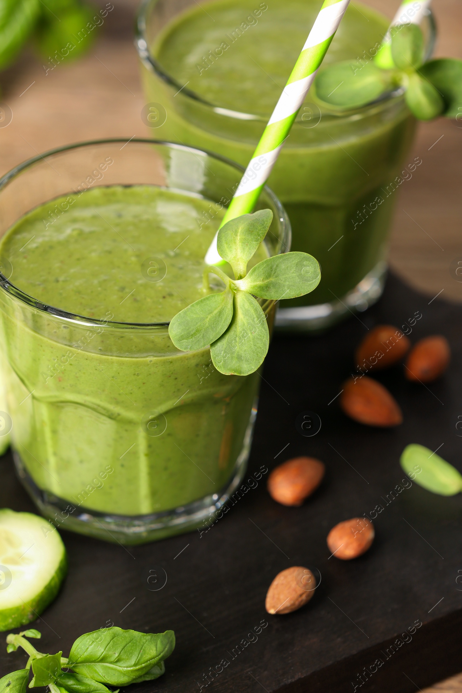 Photo of Fresh green smoothie and ingredients on wooden board, closeup