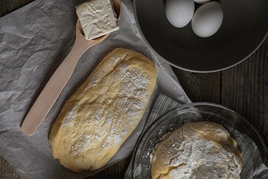 Photo of Raw dough, eggs and flour on wooden table, flat lay. Cooking ciabatta