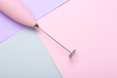 Pink milk frother wand on color background, top view. Space for text