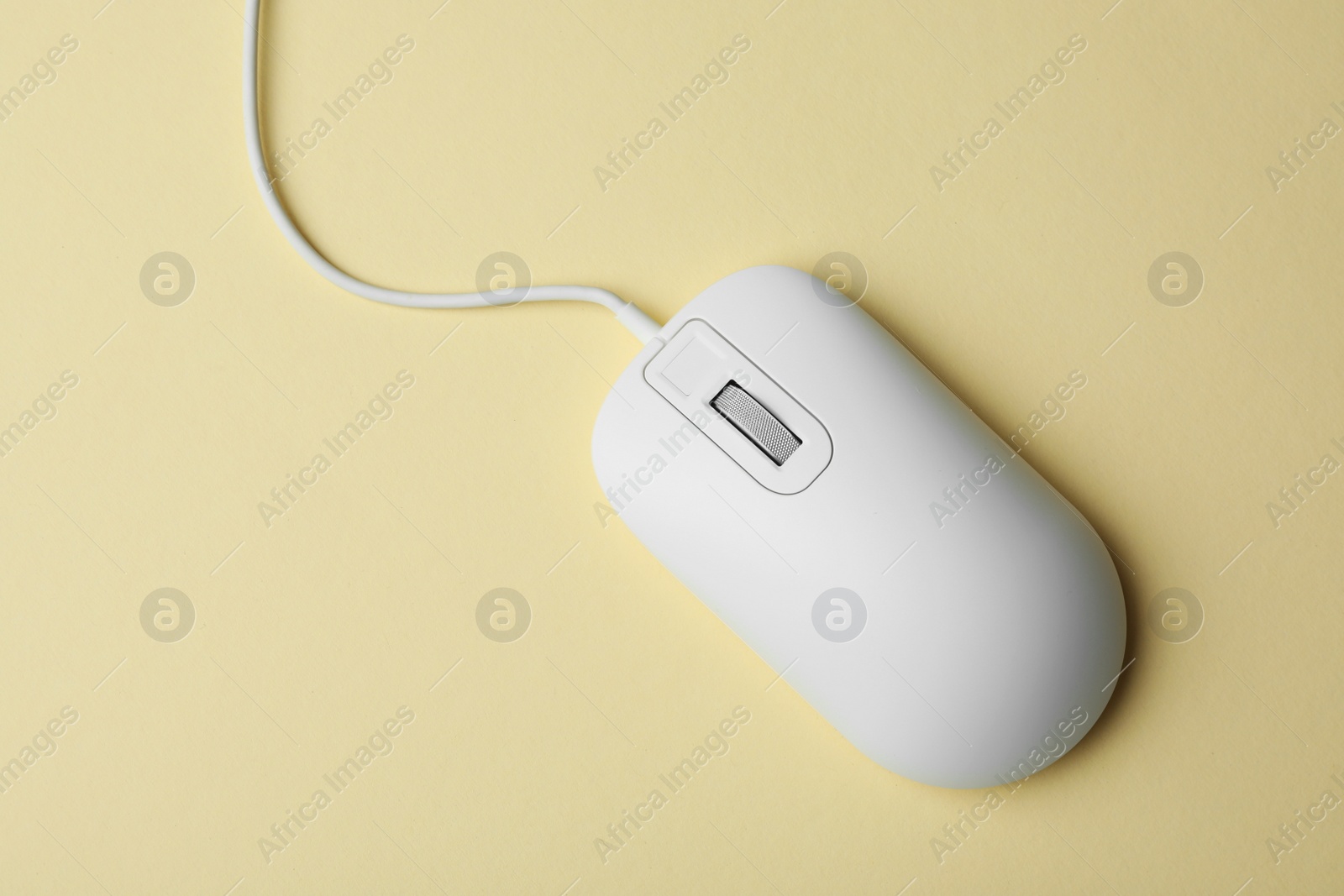 Photo of Wired computer mouse on yellow background, top view