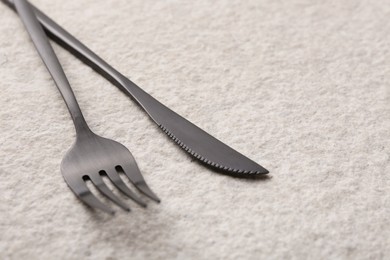 Stylish cutlery on beige textured table, closeup. Space for text