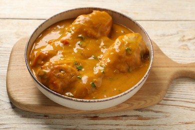 Tasty chicken curry on wooden table, closeup