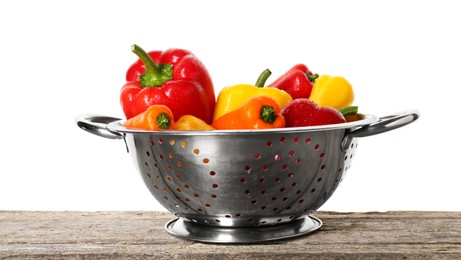 Photo of Metal colander with fresh peppers on wooden table against white background