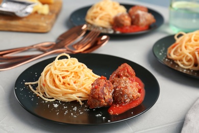 Photo of Delicious pasta with meatballs and tomato sauce on table