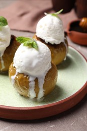 Delicious baked apples with ice cream and mint served on grey table