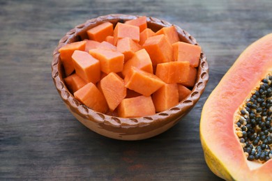 Photo of Tasty ripe cut papaya fruits on wooden table, closeup