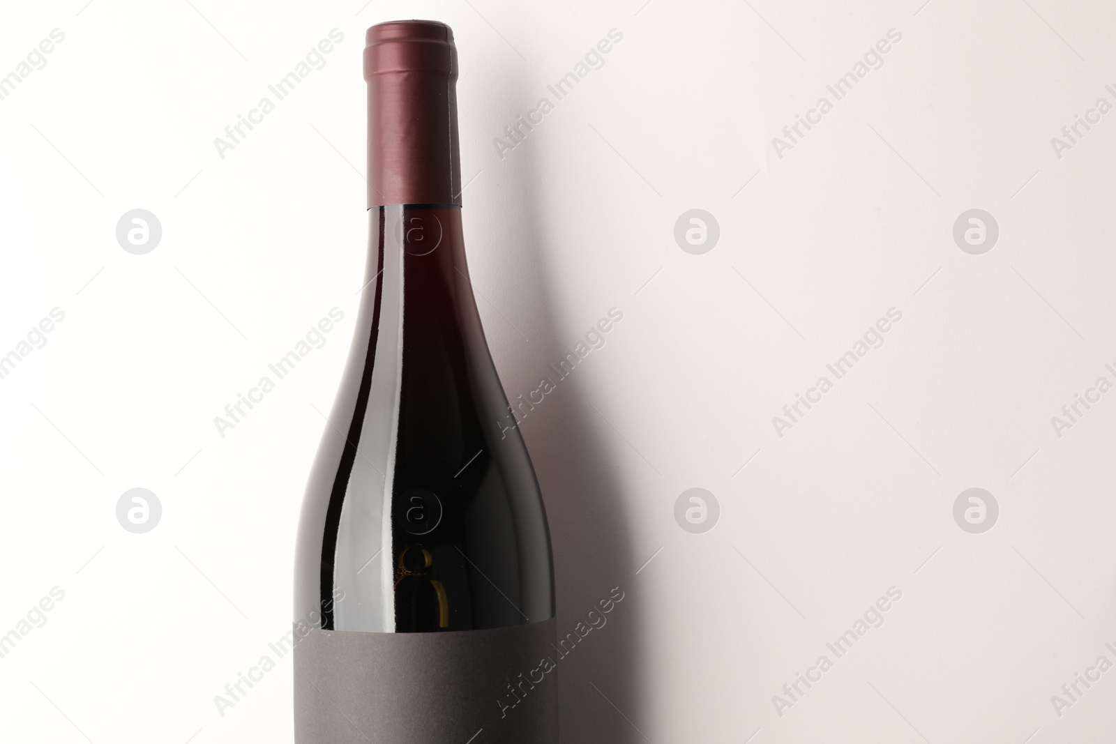 Photo of Bottle of tasty red wine on white background, top view. Space for text