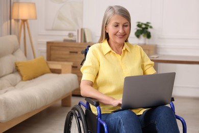 Photo of Woman in wheelchair using laptop at home