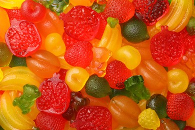 Photo of Mix of different delicious gummy candies as background, top view