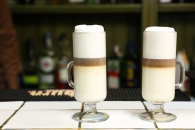 Tasty coffee drinks on table in cafe