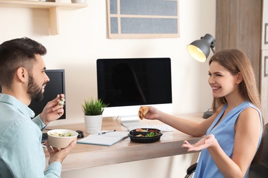 Photo of Office employees having lunch at workplace. Food delivery