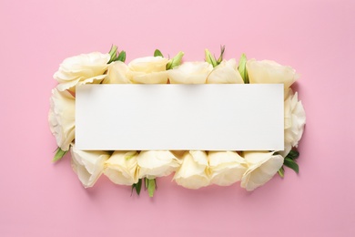 Beautiful Eustoma flowers and blank card on pink background, flat lay. Space for text