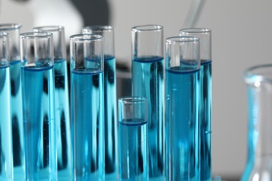 Test tubes with light blue liquid in laboratory, closeup