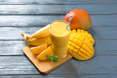 Tasty tropical drink with mango and fresh fruits on wooden table