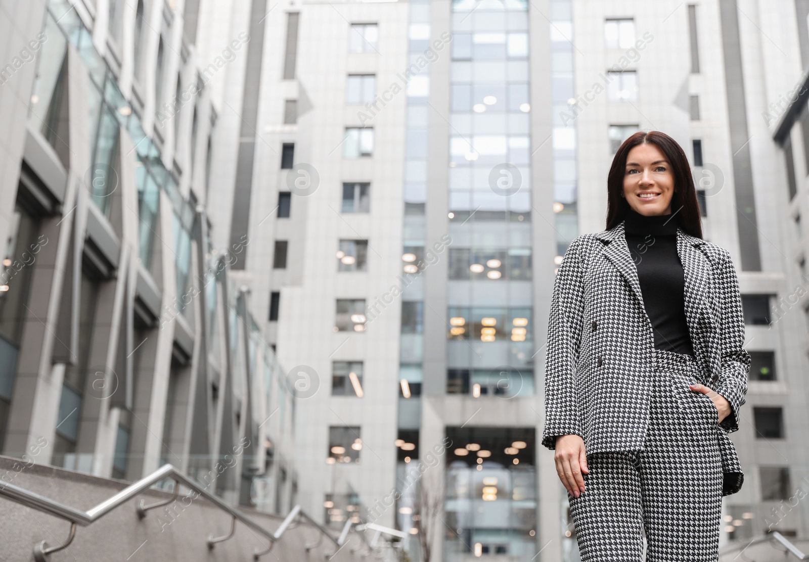 Photo of Portrait of beautiful woman in stylish suit on city street. Space for text