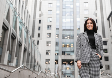 Photo of Portrait of beautiful woman in stylish suit on city street. Space for text